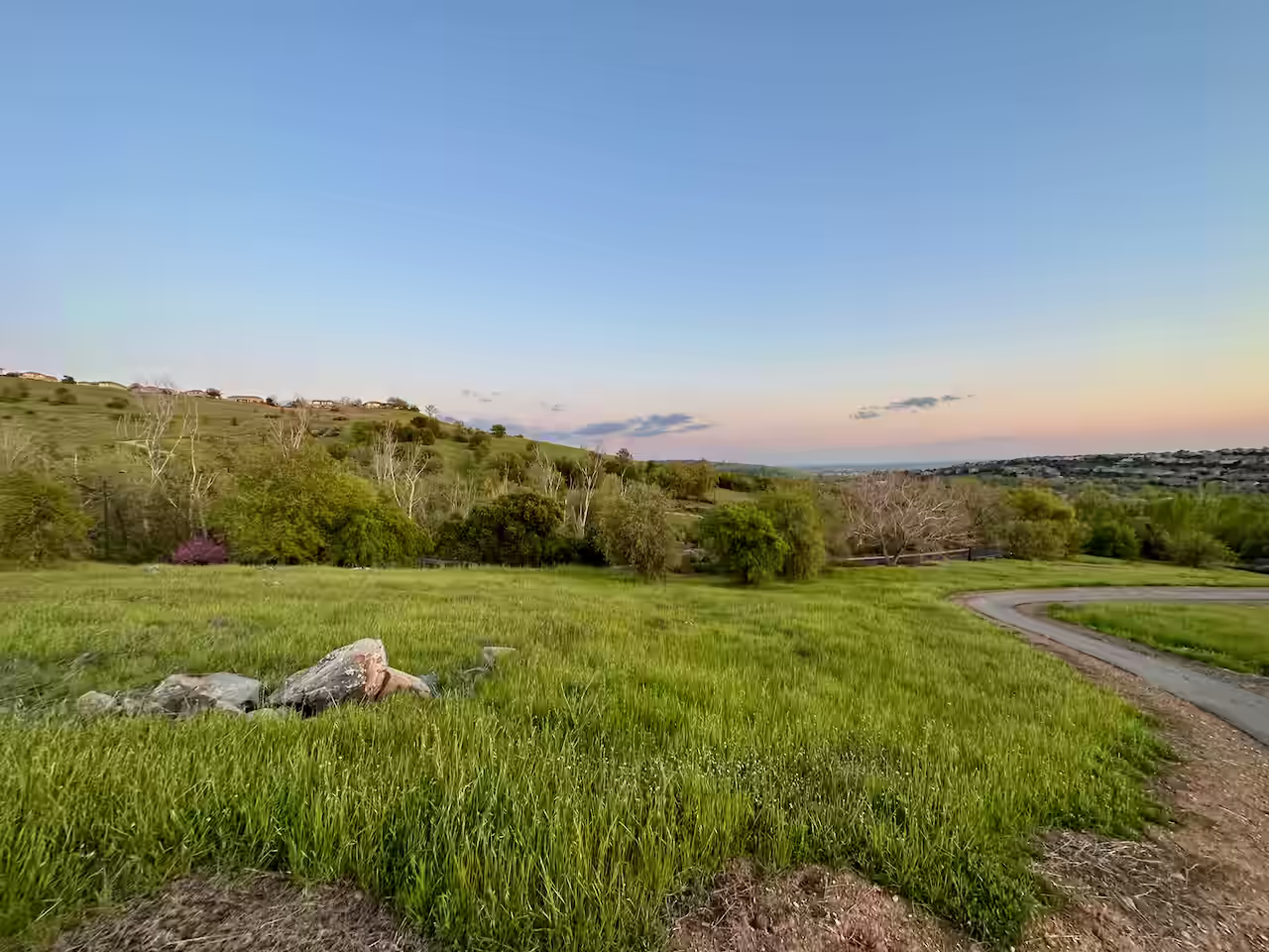 walking trail surrounded by green rolling hills